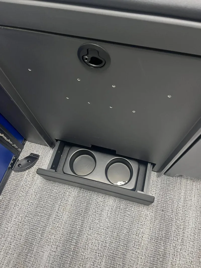 Slide: The Image of 2025 Bennington 24 MSB boat interior with built-in cup holders and storage compartment. - 13