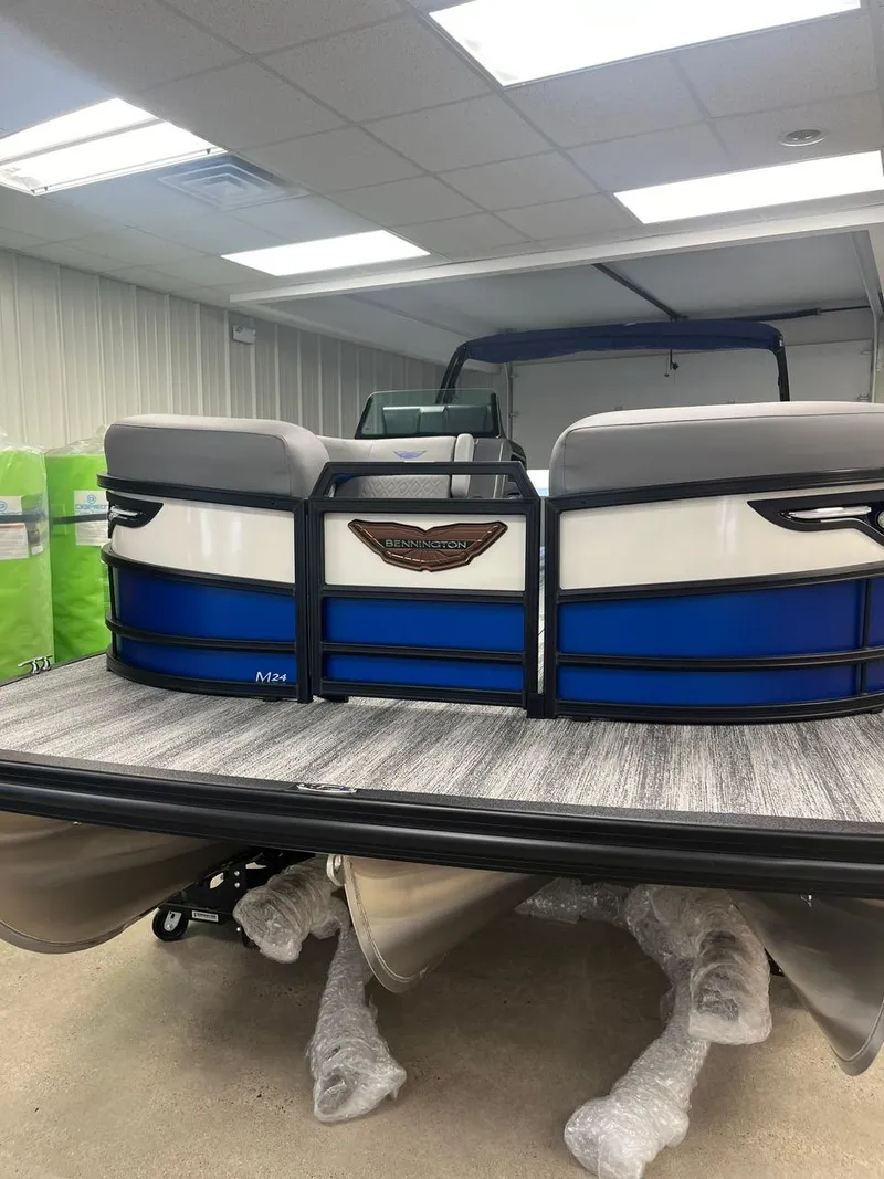 Slide: The Image of 2025 Bennington 24 MSB pontoon boat with blue and white design in showroom. - 17