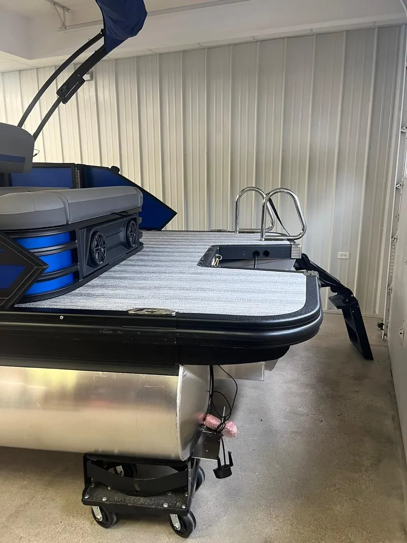 Slide: The Image of 2025 Bennington 24 MSB pontoon boat in storage, featuring sleek design and modern amenities. - 19