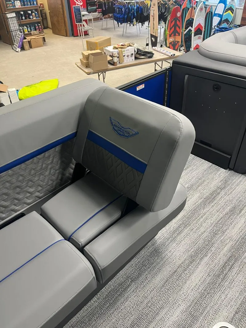 Slide: The Image of 2025 Bennington 24 MSB boat interior with gray and blue seating in a showroom. - 6