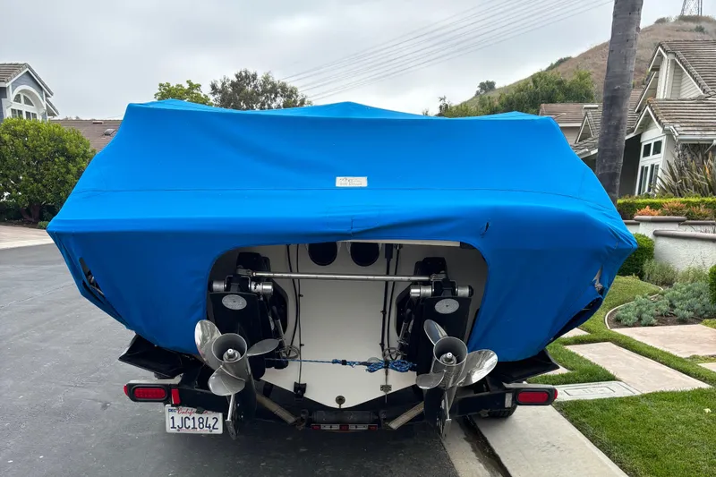 Slide: The Image of 1998 Wellcraft Scarab 30 boat with blue cover, parked on a residential street. - 11