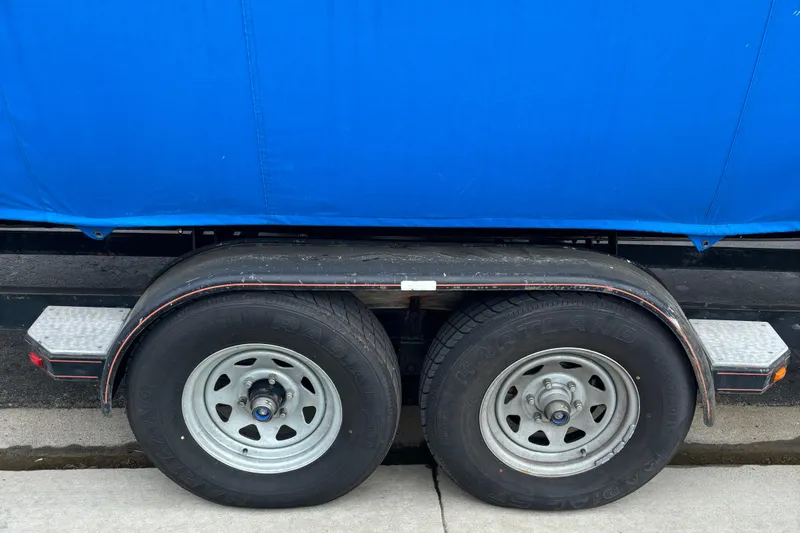 Slide: The Image of Trailer wheels of a 1998 Wellcraft Scarab 30 boat, covered in blue tarp. - 12