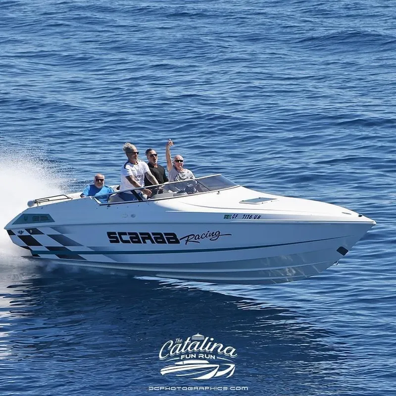 Slide: The Image of 1998 Wellcraft Scarab 30 speedboat with passengers enjoying a ride on the ocean. - 2