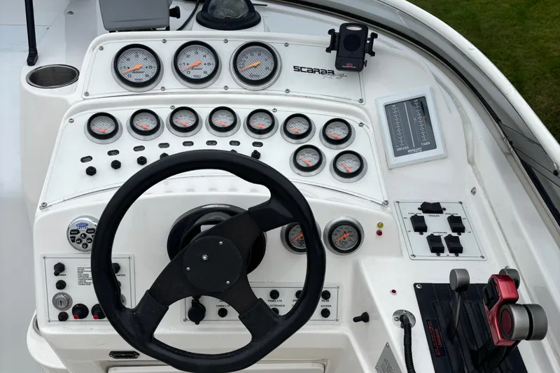 Slide: The Image of Control panel of a 1998 Wellcraft Scarab 30 boat with gauges and steering wheel. - 5