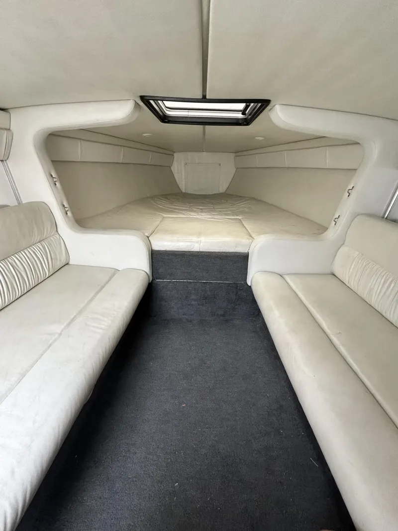 Slide: The Image of 1998 Wellcraft Scarab 30 interior cabin with white seating and skylight. - 6