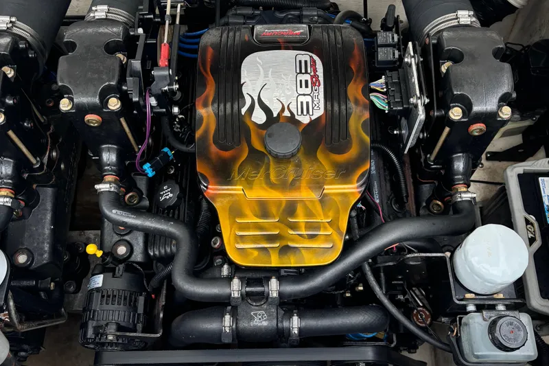 Slide: The Image of 1998 Wellcraft Scarab 30 engine with custom flame design on cover. - 9