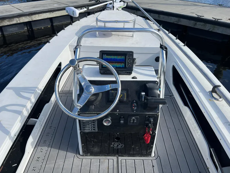 Slide: The Image of 2024 Deno 17 Flats boat cockpit with steering wheel and navigation system. - 4