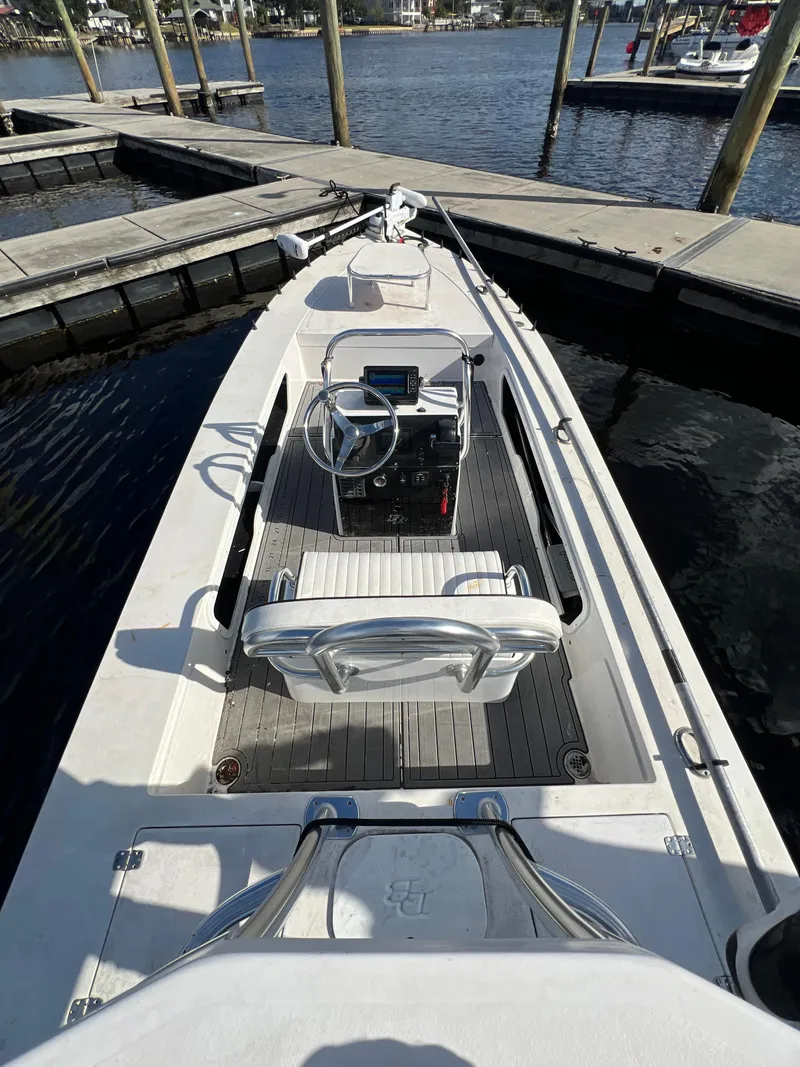 Slide: The Image of 2024 Deno 17 Flats boat docked at marina, featuring sleek design and modern controls. - 7