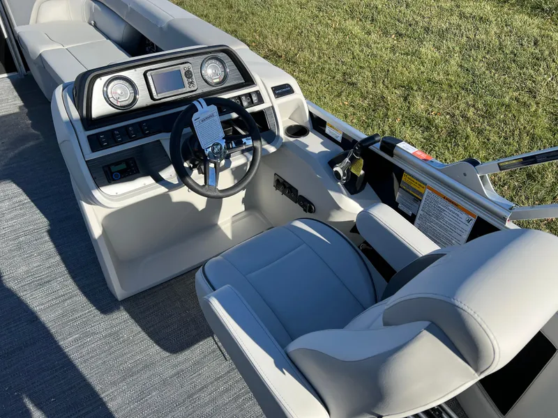 Slide: The Image of 2025 Godfrey Sweetwater 2286 C Special Edition boat interior with steering wheel and seating. - 19