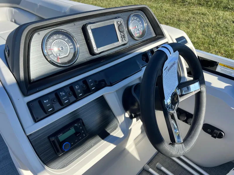 Slide: The Image of Dashboard of 2025 Godfrey Sweetwater 2286 C Special Edition boat, featuring steering wheel and controls. - 20