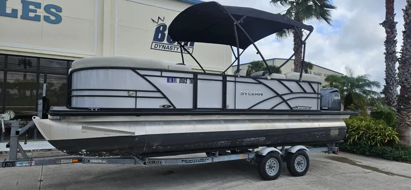 Slide: The Image of 2023 Sylvan Mirage X3 Tritoon boat on trailer, parked outdoors. - 4