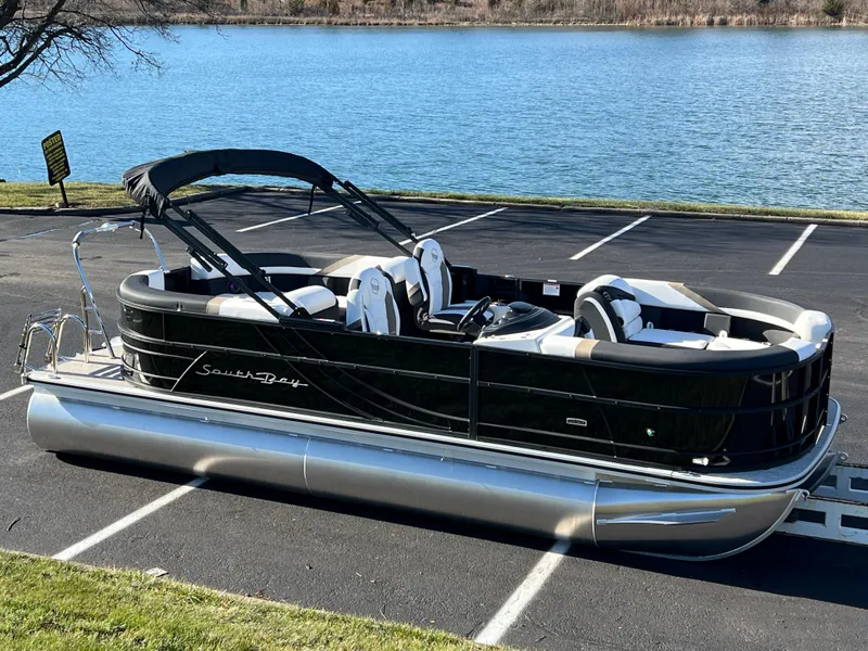 Slide: The Image of 2025 South Bay 222 RS pontoon boat parked by a lake. - 1