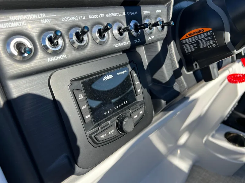 Slide: The Image of Control panel of 2025 South Bay 222 RS boat with switches and audio system. - 22