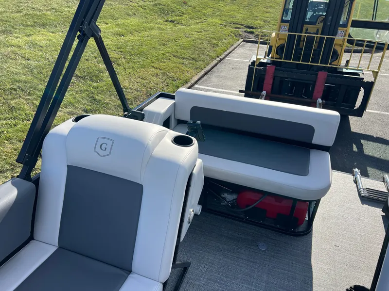 Slide: The Image of Godfrey Mighty G 1476 C 2025 boat interior with cushioned seating and forklift in background. - 10