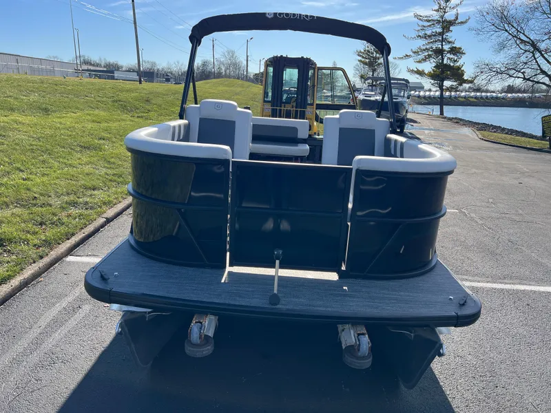 Slide: The Image of 2025 Godfrey Mighty G 1476 C pontoon boat, rear view, parked on pavement. - 2