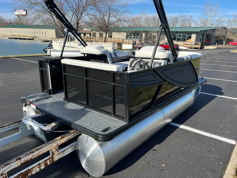 Slide: The Image of 2025 Godfrey Mighty G 1476 C pontoon boat on trailer in parking lot. - 5