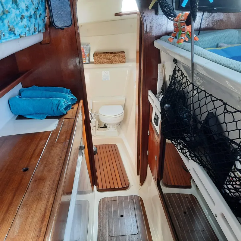 Slide: The Image of Interior of 2006 Gemini 105 MC sailboat with wooden finishes and compact bathroom. - 10