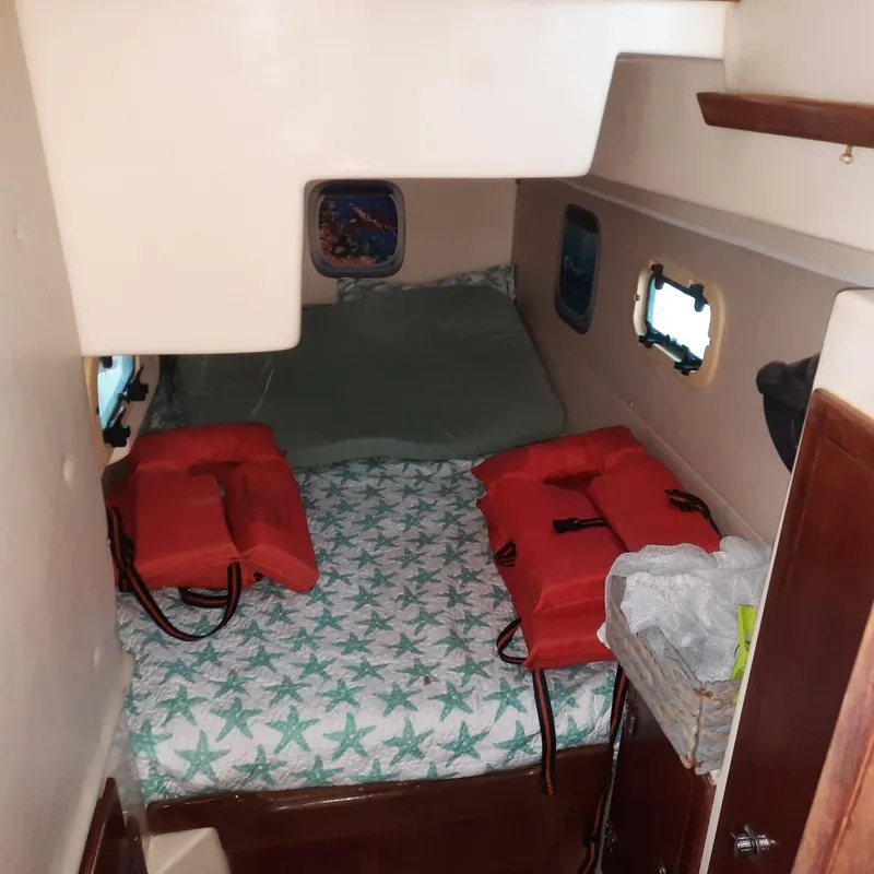 Slide: The Image of Interior cabin of 2006 Gemini 105 MC with life jackets on bed. - 13