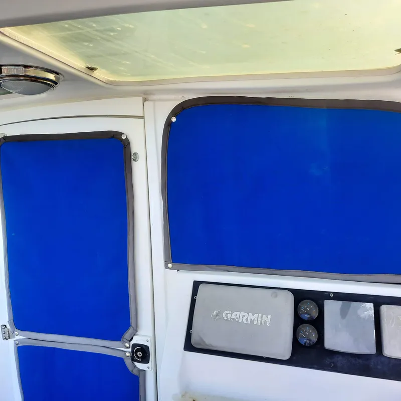 Slide: The Image of Interior of 2006 Gemini 105 MC boat with blue covers and Garmin equipment. - 2