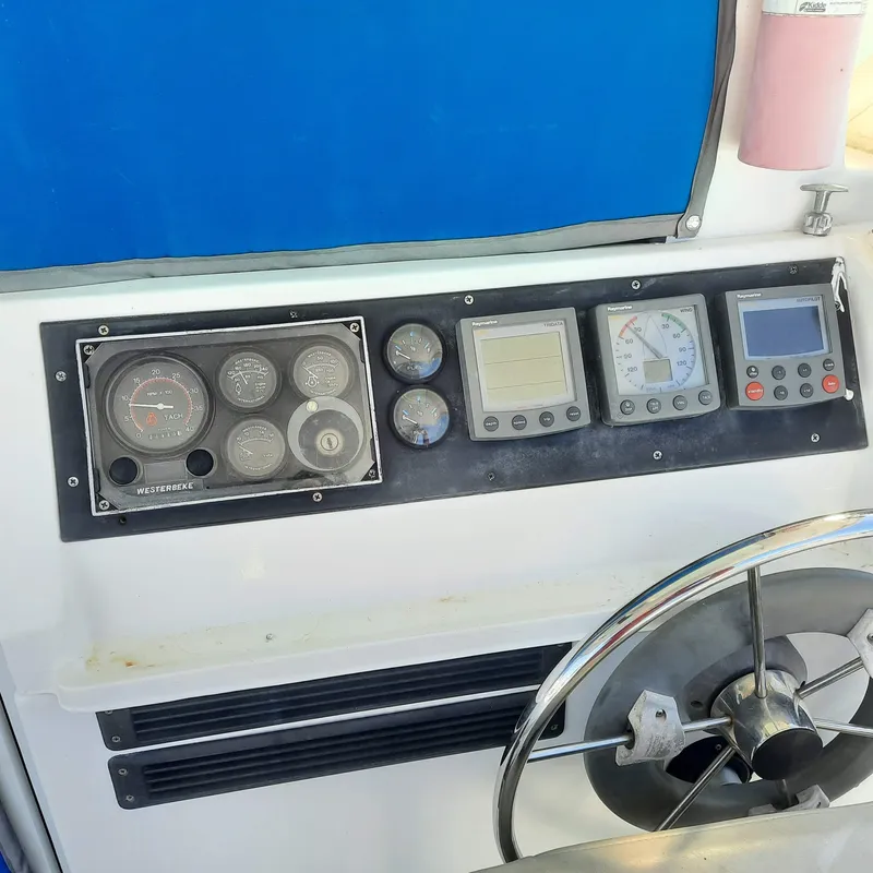 Slide: The Image of Control panel of a 2006 Gemini 105 MC boat with gauges and steering wheel. - 3