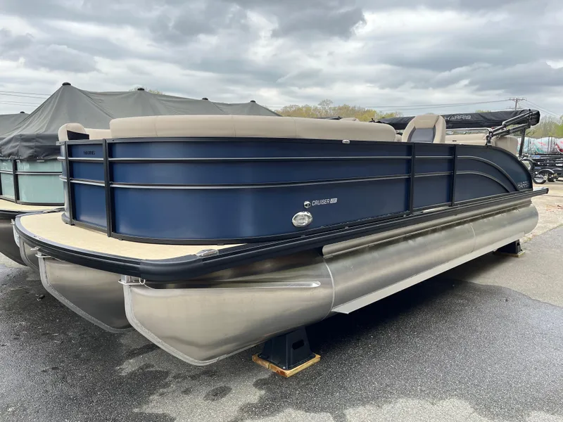 The Image of 2025 Harris Cruiser 230 pontoon boat with sleek design, docked under cloudy skies. - 0