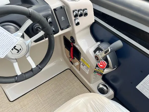 Slide: The Image of 2025 Harris Cruiser 230 boat dashboard with steering wheel and control panel. - 12