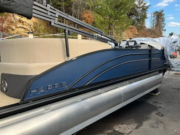Slide: The Image of 2025 Harris Cruiser 230 pontoon boat with sleek design, docked outdoors. - 3