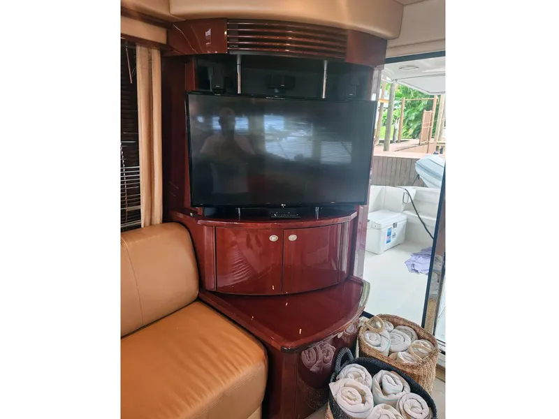 Slide: The Image of Luxurious interior of 2007 Sea Ray 52 Sedan Bridge with TV and seating area. - 11