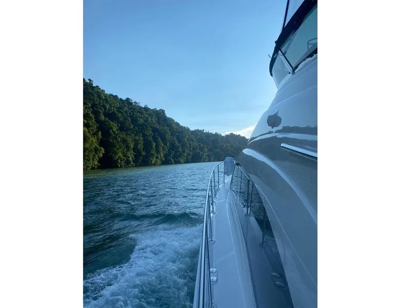 Slide: The Image of 2007 Sea Ray 52 Sedan Bridge cruising on a scenic waterway with lush greenery. - 3