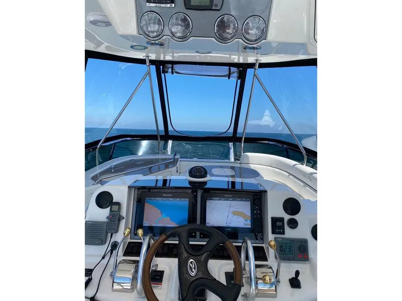 Slide: The Image of 2007 Sea Ray 52 Sedan Bridge helm with navigation screens and steering wheel. - 6