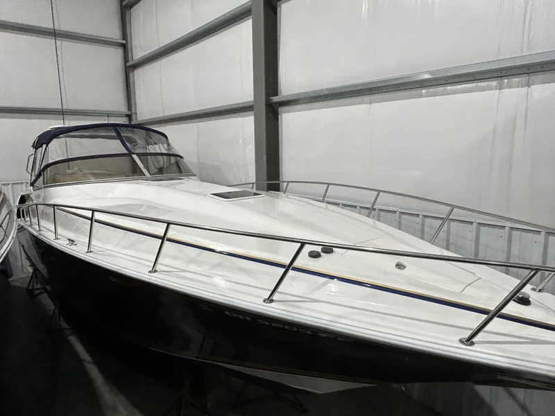 Slide: The Image of 2002 Fountain 38 Express Cruiser in storage, sleek design, white hull, enclosed cabin. - 4