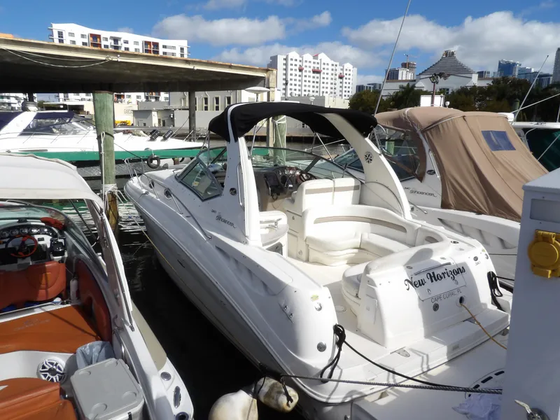 Slide: The Image of 2004 Sea Ray 320 Sundancer docked at marina with cityscape background. - 1