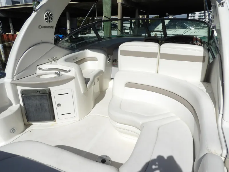 Slide: The Image of 2004 Sea Ray 320 Sundancer boat interior with white seating and helm station. - 11