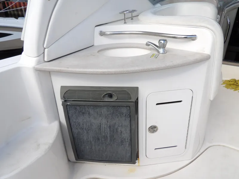 Slide: The Image of 2004 Sea Ray 320 Sundancer boat kitchenette with sink and mini fridge. - 12