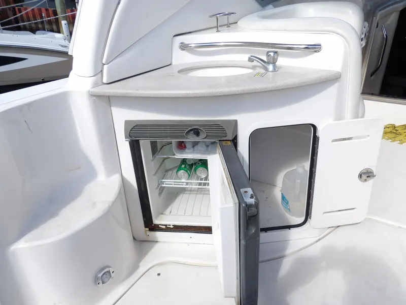 Slide: The Image of 2004 Sea Ray 320 Sundancer boat kitchenette with sink and mini fridge. - 13
