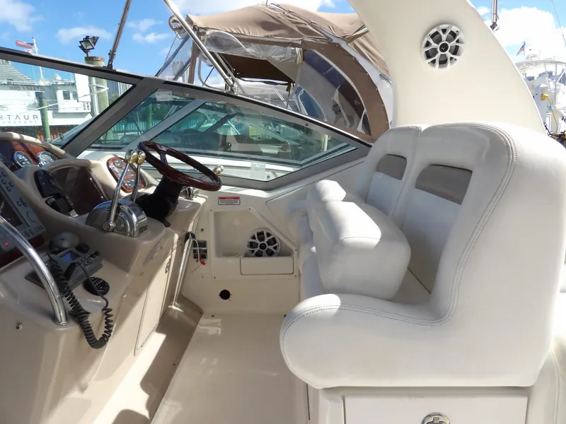 Slide: The Image of Interior cockpit of 2004 Sea Ray 320 Sundancer with white seating and steering wheel. - 15