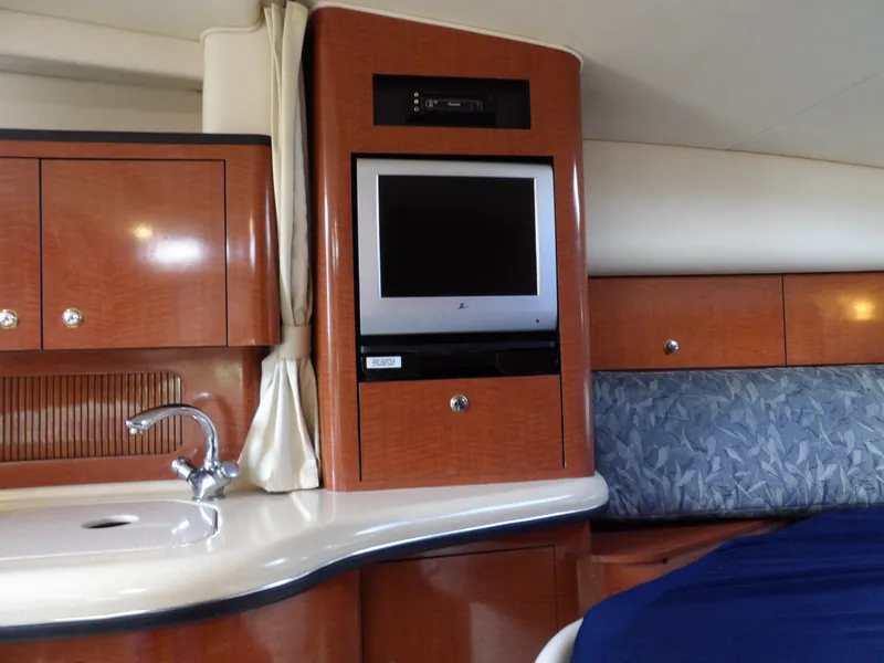 Slide: The Image of Interior of 2004 Sea Ray 320 Sundancer with TV, sink, and wood cabinetry. - 41