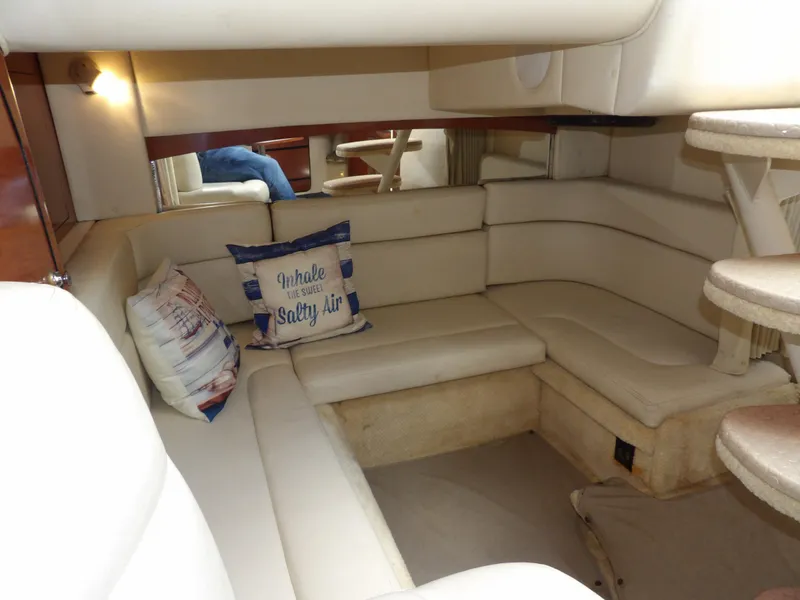 Slide: The Image of Interior of 2004 Sea Ray 320 Sundancer with beige seating and nautical-themed pillows. - 48