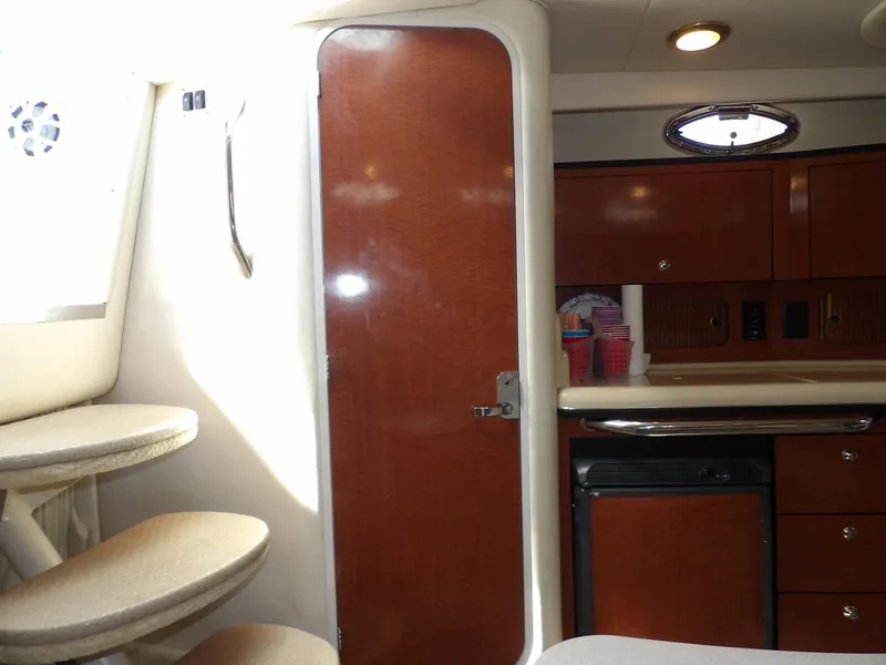 Slide: The Image of Interior of 2004 Sea Ray 320 Sundancer with wooden cabinetry and compact kitchen area. - 49
