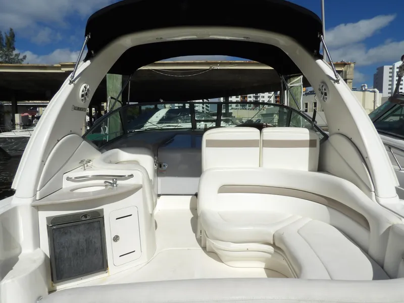 Slide: The Image of 2004 Sea Ray 320 Sundancer boat interior with white seating and canopy. - 8