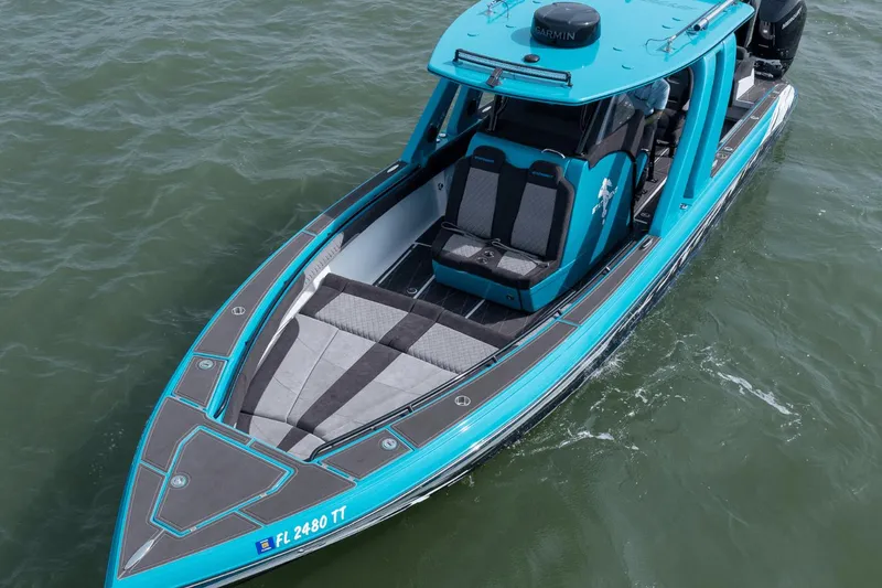 Slide: The Image of 2024 Statement 38 Open boat in vibrant blue on water, showcasing sleek design and seating. - 26