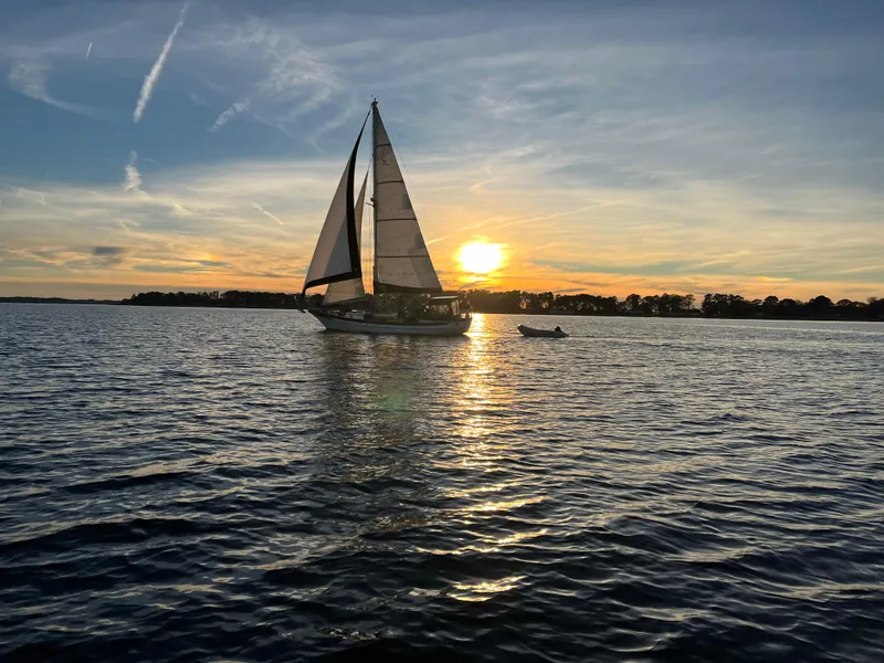 The Image of Sailboat Cabo Rico 38, 1988, cruising at sunset on calm waters. - 0