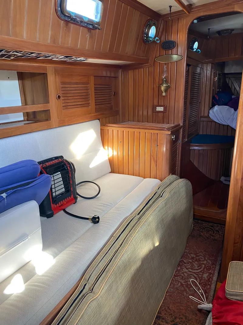 Slide: The Image of Interior of 1988 Cabo Rico 38 sailboat with wooden paneling and cozy seating area. - 11