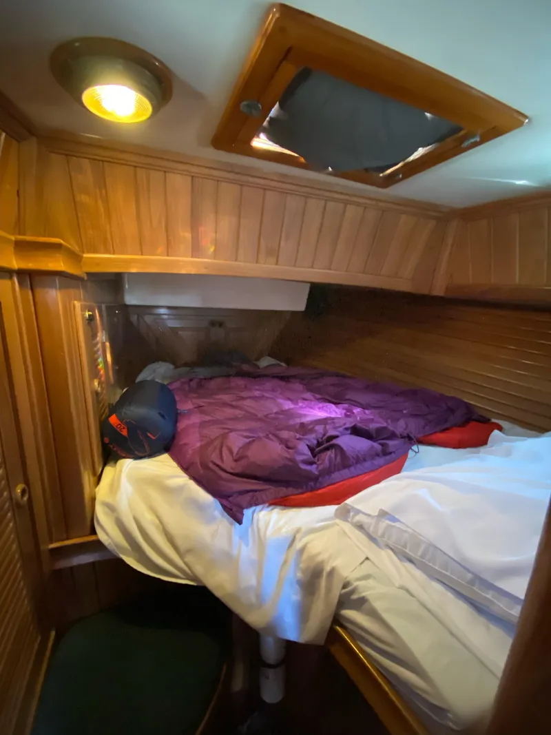Slide: The Image of Cozy cabin interior of 1988 Cabo Rico 38 sailboat with wood paneling and bedding. - 12
