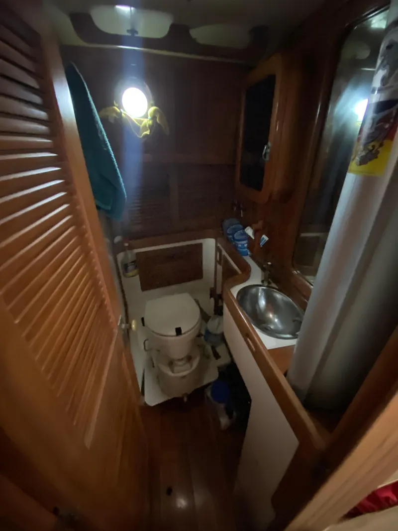 Slide: The Image of 1988 Cabo Rico 38 yacht bathroom with wooden interior and compact design. - 17