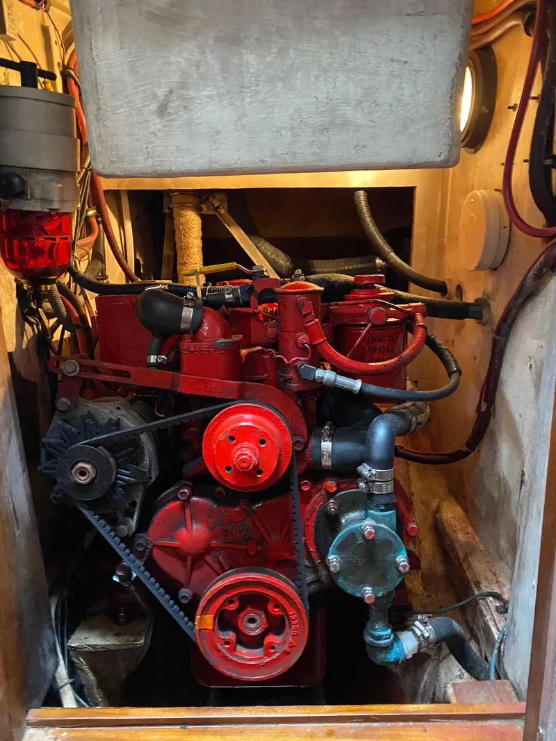 Slide: The Image of Engine compartment of a 1988 Cabo Rico 38 sailboat, featuring a red marine engine. - 18