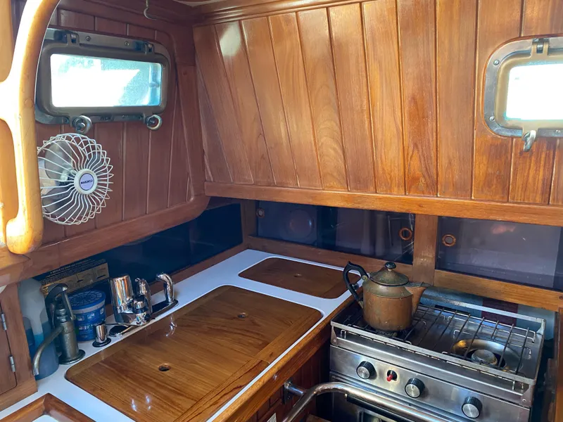 Slide: The Image of 1988 Cabo Rico 38 yacht kitchen with wooden cabinetry, stove, and sink. - 5