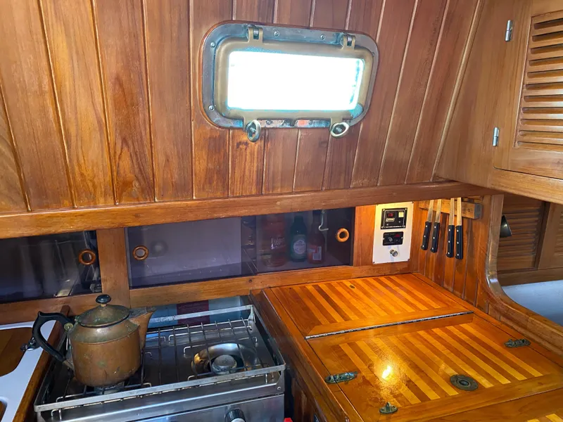 Slide: The Image of Cabo Rico 38 yacht galley with wooden cabinetry and stove, 1988 model. - 6