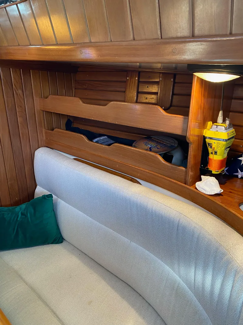 Slide: The Image of Interior of 1988 Cabo Rico 38 sailboat with wooden paneling and cozy seating. - 9