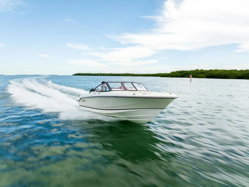 Slide: The Image of 2024 Boston Whaler 210 Vantage cruising on open water under a clear sky. - 24
